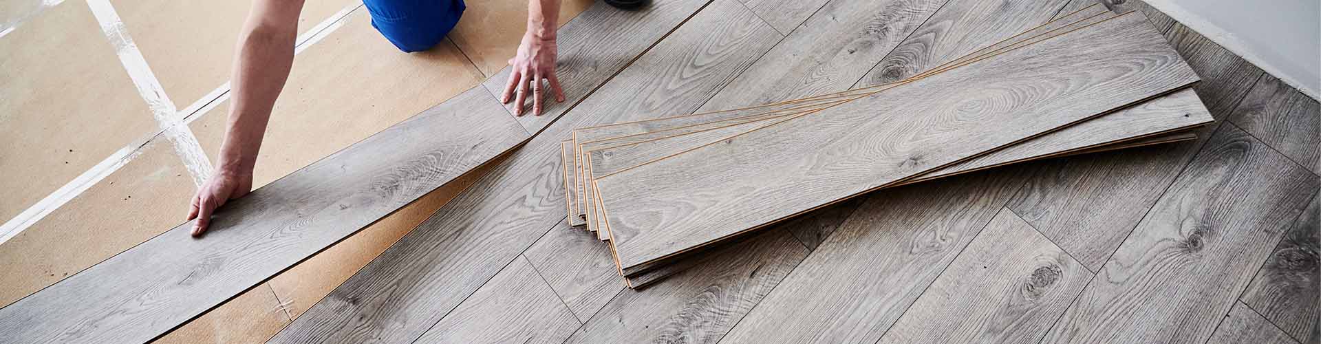 installer laying luxury vinyl plank on underlayment 