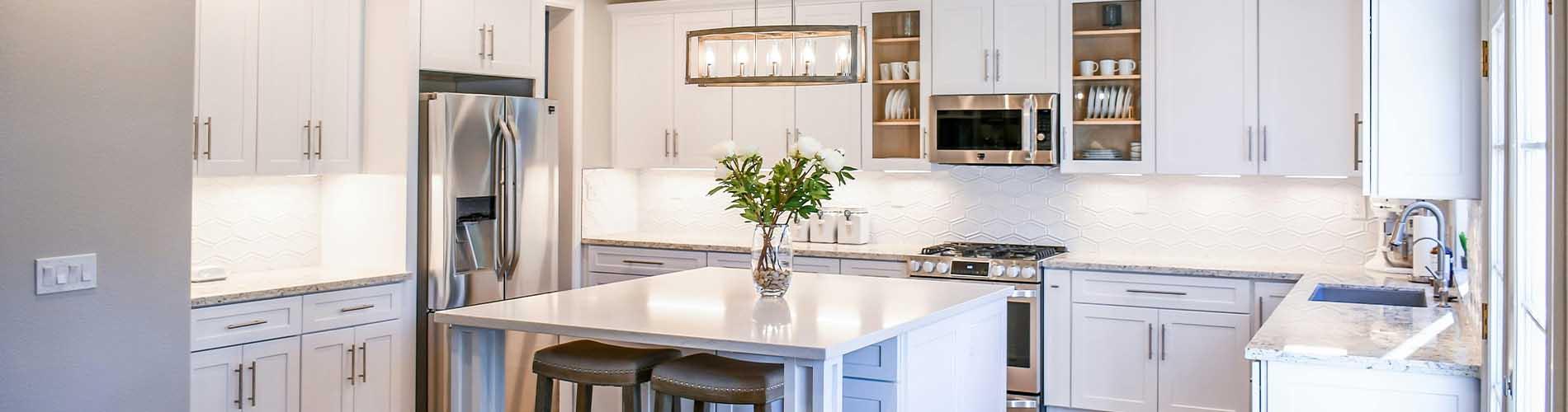 Kitchen with white cabinets and countertops and wood floors